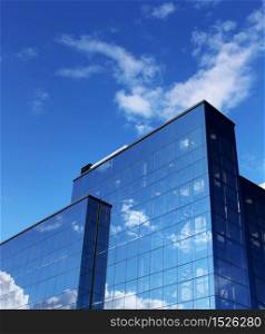 Modern office building reflecting blue sky white clouds. Modern office building blue