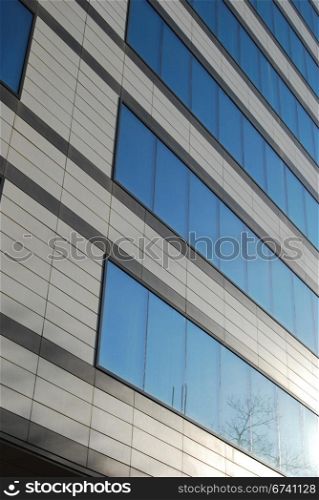 Modern office building wall with blue glass windows close-up