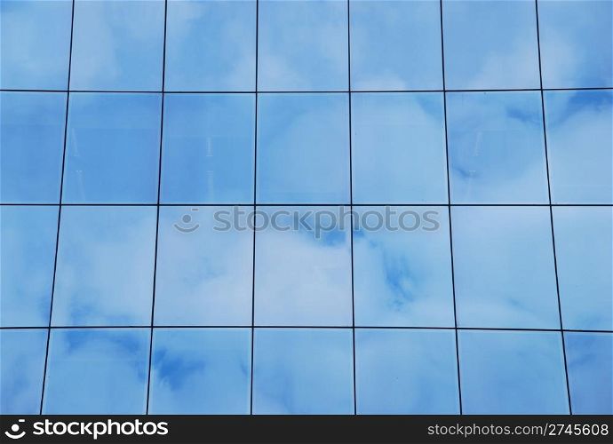 modern office building with glass pattern with clouds reflected