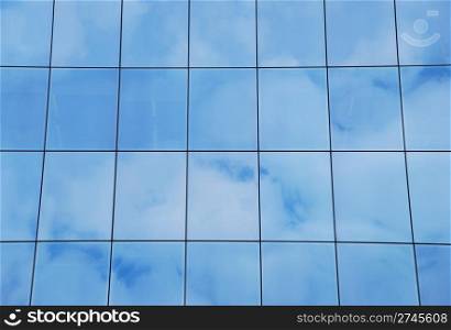 modern office building with glass pattern with clouds reflected