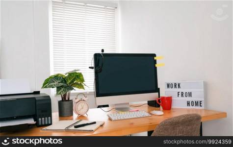 Modern office interior with electronic device, supplies and coffee cup on table