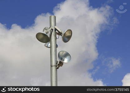 modern pole with spotlights and blue sky with clouds behind