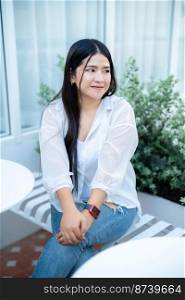 modern portrait of beautiful happy asian woman traveler wearing smartwatch wearing beautiful white dress and wear jeans lifestyle enjoying in sitting coffee shop restaurant background