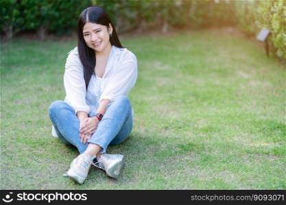 modern portrait of beautiful happy asian woman traveler wearing smartwatch wearing beautiful white dress and wear jeans lifestyle enjoying in sitting in the grass background