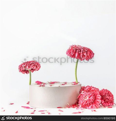 Modern product display with podium, pink flowers and petals at white background. Scene stage showcase. Front view with copy space.