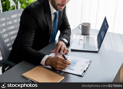 Modern professional businessman at modern office desk using laptop to work and write notes. Diligent office worker working on computer notebook in his office work space. fervent. Modern professional businessman at modern office desk. fervent