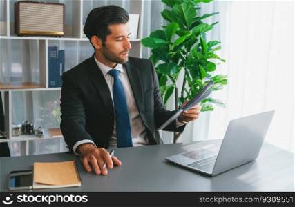 Modern professional businessman at modern office desk using laptop to work and write notes. Diligent office worker working on computer notebook in his office work space. fervent. Modern professional businessman at modern office desk. fervent