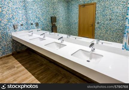 Modern public wc, blue colors.Wash basin in a public restroom