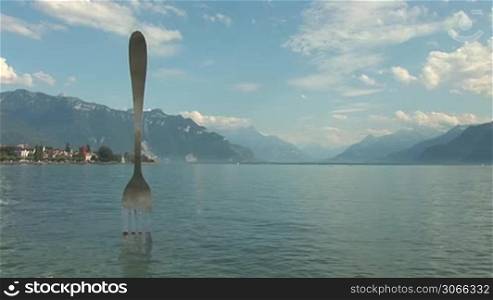 modern sculpture - a fork sticking out of Lake Geneva