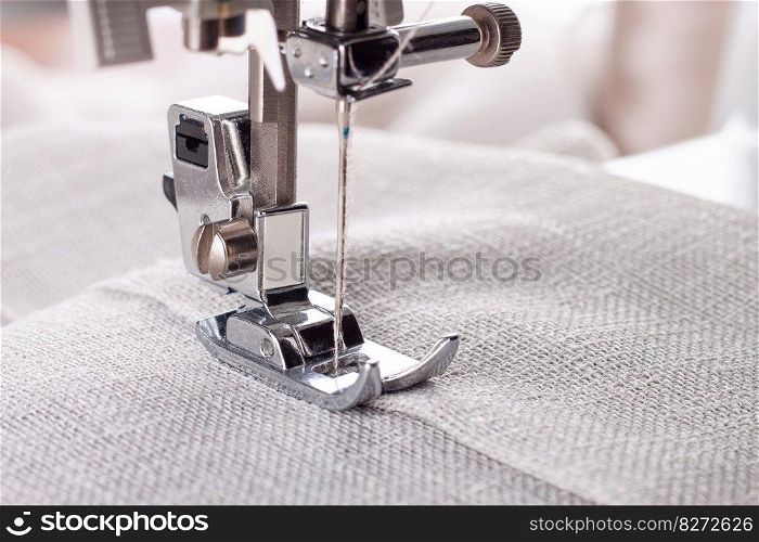 Modern sewing machine presser foot with linen fabric and thread, closeup. Sewing process clothes, curtains, upholstery. Business, hobby, handmade, zero waste, recycling, repair concept