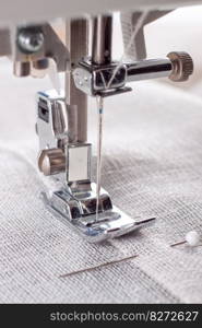 Modern sewing machine presser foot with linen fabric and thread, closeup. Sewing process clothes, curtains, upholstery. Business, hobby, handmade, zero waste, recycling, repair concept