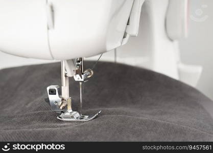 Modern sewing machine with gray fabric and. Sewing process clothes, curtains, upholstery. Business, hobby, handmade, zero waste, recycling, repair concept