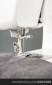 Modern sewing machine with gray fabric and. Sewing process clothes, curtains, upholstery. Business, hobby, handmade, zero waste, recycling, repair concept