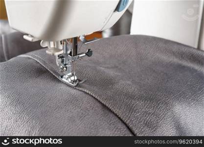 Modern sewing machine with gray velours fabric. Sewing process clothes, curtains upholstery. Business, hobby, handmade, zero waste, recycling, repair concept