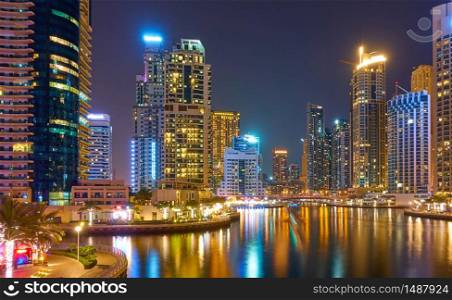 Modern skyscrapers of Dubai Marina at night and its reflections in the water, United Arab Emirates