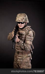 Modern soldier with rifle isolated on a black background