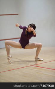modern style ballet dancer woman posing and jumping on training in gym