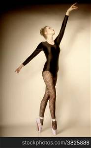 modern style beautiful woman ballet dancer full length in studio sepia