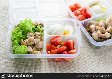 Modern style clean food, boiled egg, grilled chicken and avocado, strawberry, vegetable salad