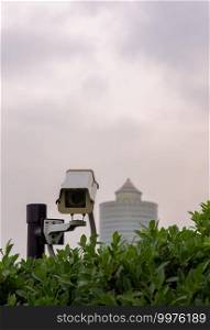 Modern surveillance cameras in the park with Tall building background, the concept of surveillance and visual inspection that has been developed, Selective focus.