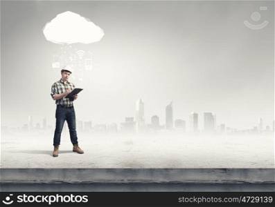 Modern technologies in construction. Young man builder with folder and media cloud above head