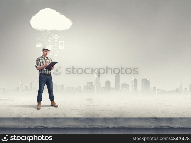 Modern technologies in construction. Young man builder with folder and media cloud above head