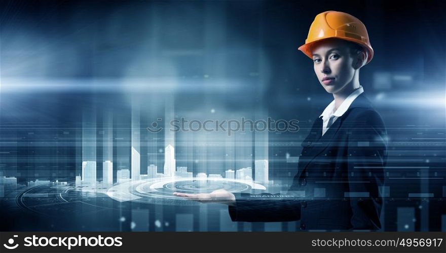 Modern technologies in use. Attractive engineer woman in helmet using virtual panel