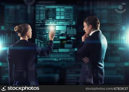 Modern technologies in use. Rear view of businessman and businesswoman working with virtual panel interface