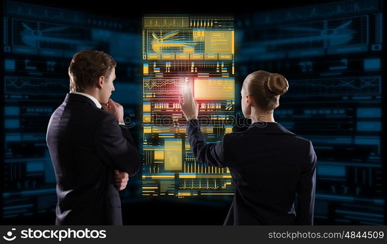 Modern technologies in use. Rear view of businessman and businesswoman working with virtual panel interface