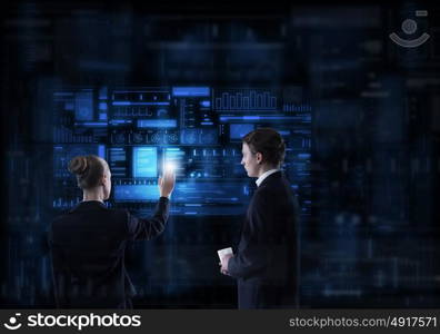 Modern technologies in use. Rear view of businessman and businesswoman working with virtual panel interface