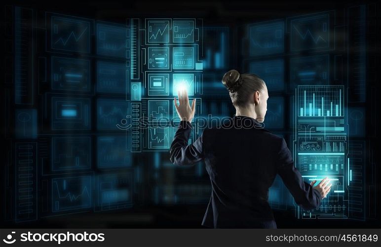 Modern technologies in use. Rear view of businesswoman working with virtual panel interface