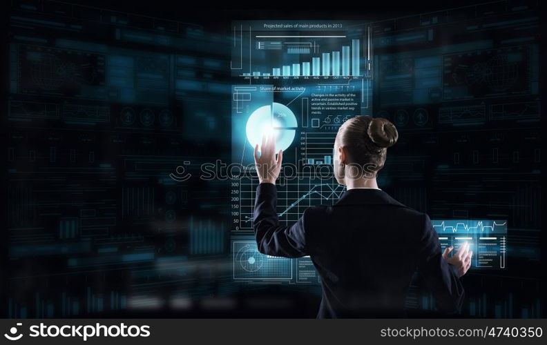 Modern technologies in use. Rear view of businesswoman working with virtual panel interface