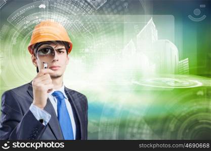 Modern technologies. Young man engineer against media background looking in magnifying glass