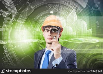 Modern technologies. Young man engineer against media background looking in magnifying glass