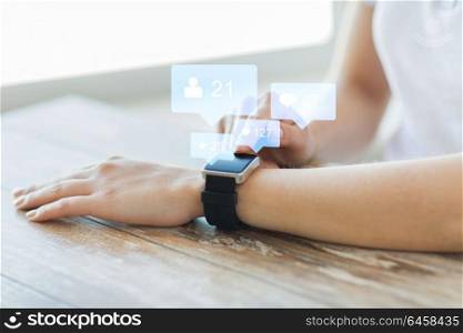modern technology and people concept - close up of woman hands wearing smart watch with social media icons. close up of smart watch with social media icons