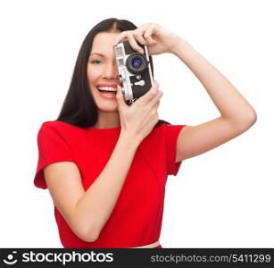 modern technology and people concept - smiling woman in casual clothes taking picture with vintage film camera