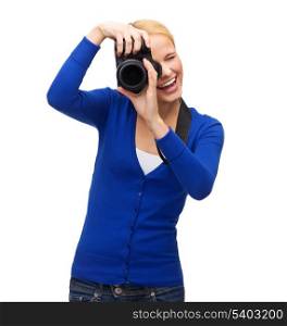modern technology and people concept - smiling woman in casual clothes taking picture with digital camera