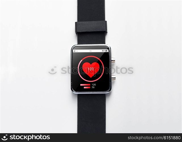 modern technology, health care, object and media concept - close up of black smart watch with heart-rate on screen