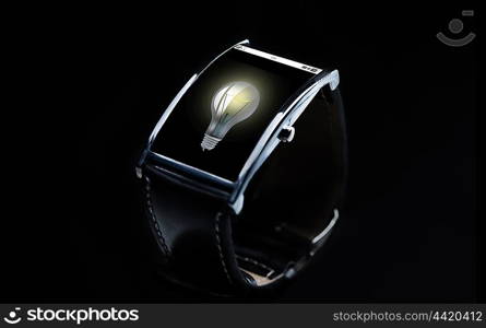 modern technology, idea, object and media concept - close up of black smart watch with light bulb icon on screen