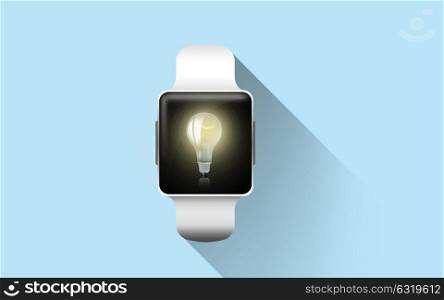 modern technology, idea, object and media concept - close up of black smart watch with light bulb icon on screen over blue background. close up of smart watch with light bulb icon