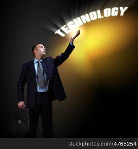 Modern technology in business. Businessman standing with modern technology symbols next to him