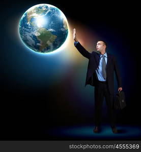 Modern technology in business. Businessman standing with our planet Earth. Elements of this image are furnished by NASA