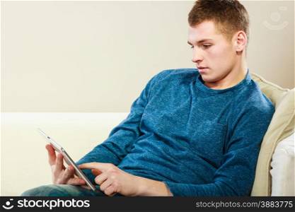 Modern technology leisure and relax concept. handsome man with pc computer tablet relaxing on couch
