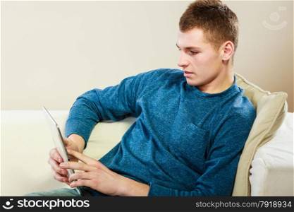 Modern technology leisure and relax concept. handsome man with pc computer tablet relaxing on couch
