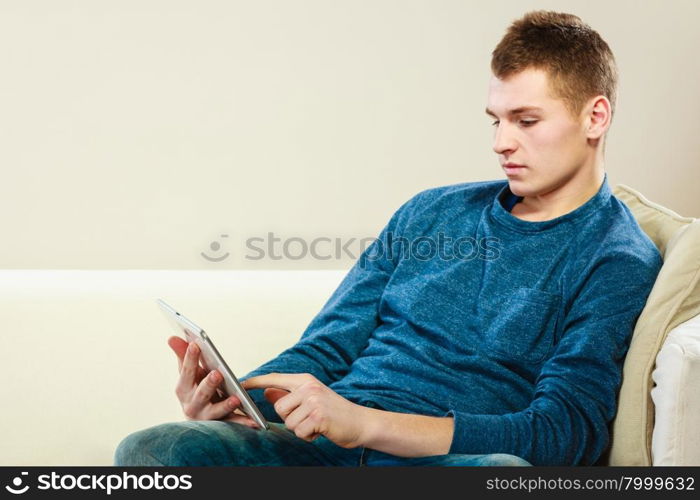 Modern technology leisure and relaxation concept. Young man with pc computer digital tablet on couch