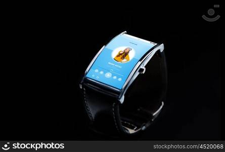 modern technology, object and media concept - close up of black smart watch with music player on screen