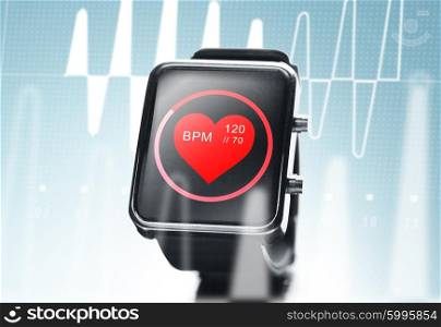 modern technology, object, health care and media concept - close up of black smart watch showing red heart beat icon on screen and cardiogram