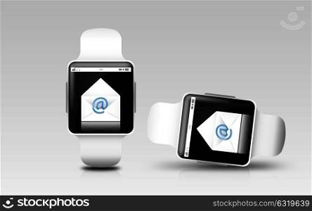 modern technology, responsive design and communication concept - smart watches with e-mail letter icon on screen over gray background. smart watches with e-mail letter icon on screen