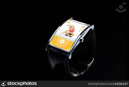modern technology, sport, object and media concept - close up of black smart watch with fitness app on screen