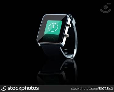 modern technology, time, object and media concept - close up of black smart watch with clock icon on screen over black background